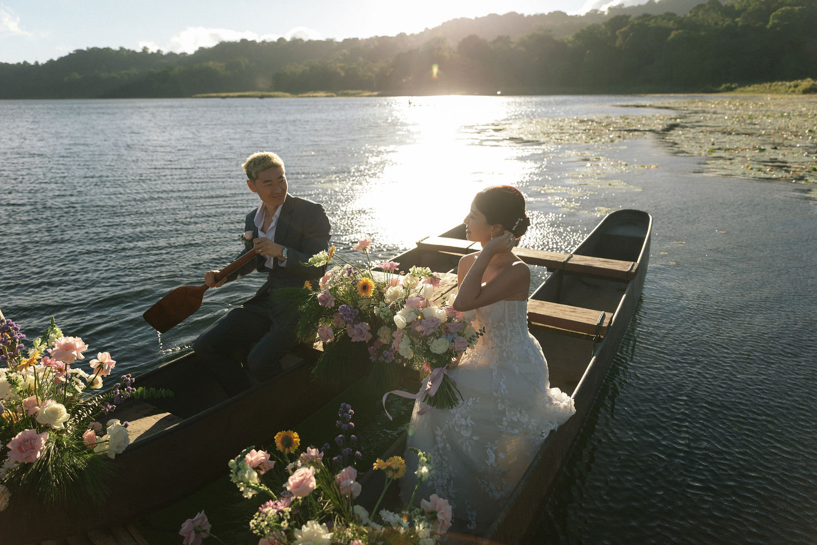 Couple rowing a traditional wooden boat in Bali