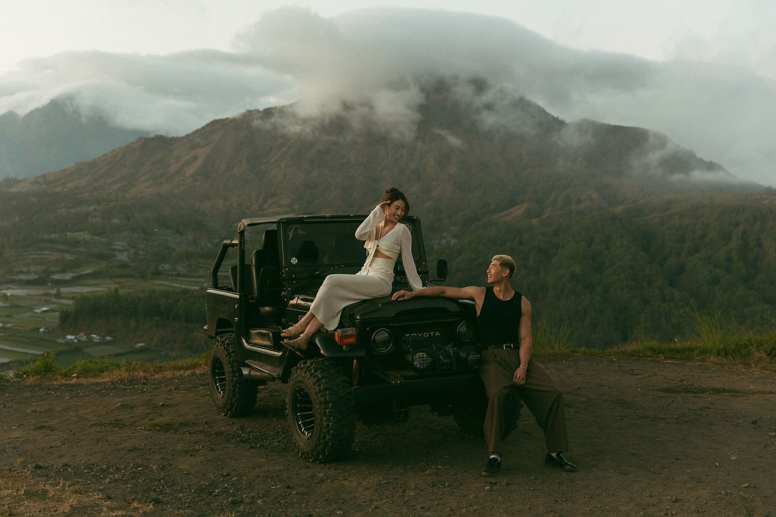Couple posing with a vintage jeep in Bali
